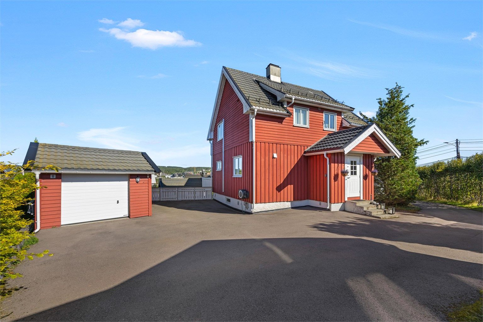 Frittliggende enebolig over tre plan med romslig gårdsplass og frittstående garasje.