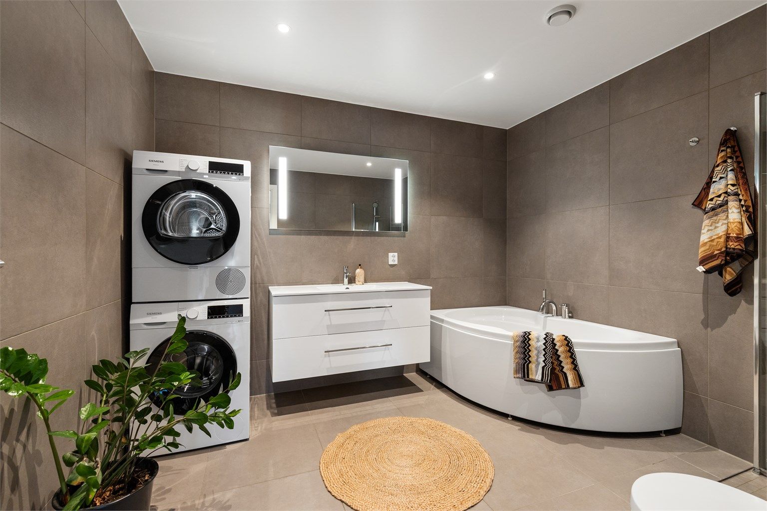 Hovedbadet har både badekar og dusjhjørne, samt opplegg for vaskesøyle.