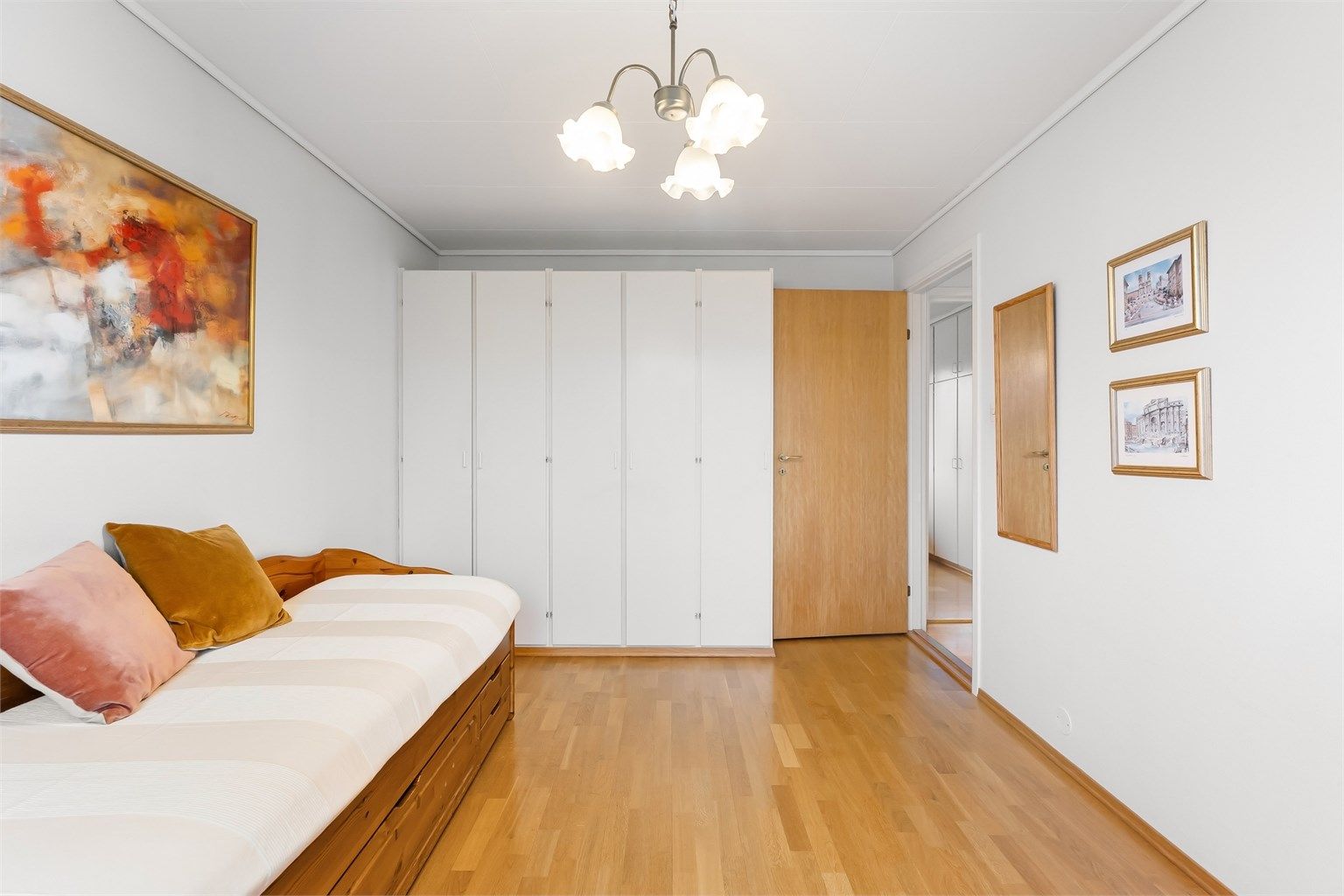 Dette rommet har en hel vegg med garderobeskap som gir rikelig med oppbevaringsplass.