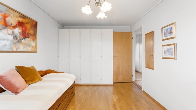 Dette rommet har en hel vegg med garderobeskap som gir rikelig med oppbevaringsplass.