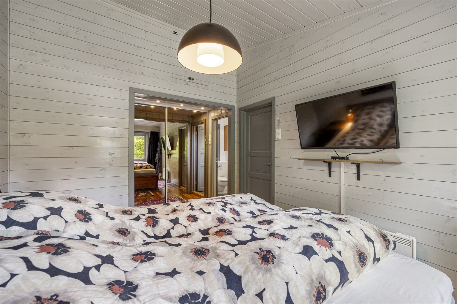 Hovedsoverom med skyvedørsgarderobe og eget bad.