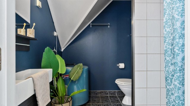 Badet er innredet med servantseksjon, gulvstående toalett og varmtvannsbereder.
