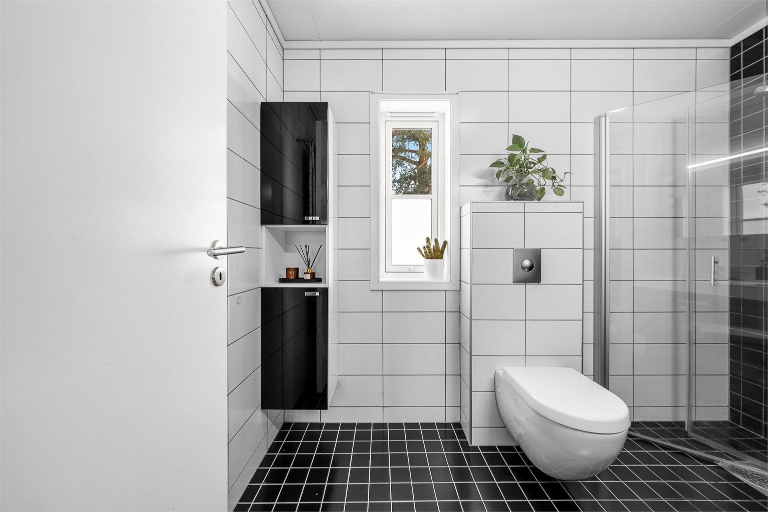 Badet har godt med innredning og det er innfellbare dusjvegger i glass. 