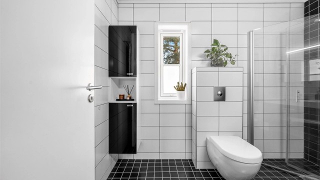 Badet har godt med innredning og det er innfellbare dusjvegger i glass.