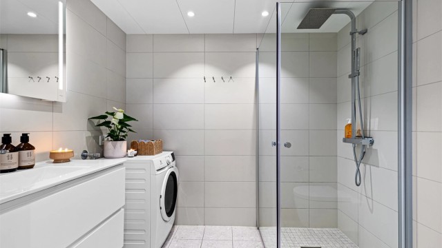 Badet har delikate og moderne fliser samt kombinert hånd/regnfallsdusj og praktiske knagger