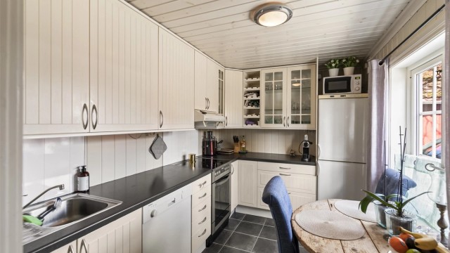 Kjøkkenet i utleiedelen har profilerte fronter og nisje for hvitevarer.