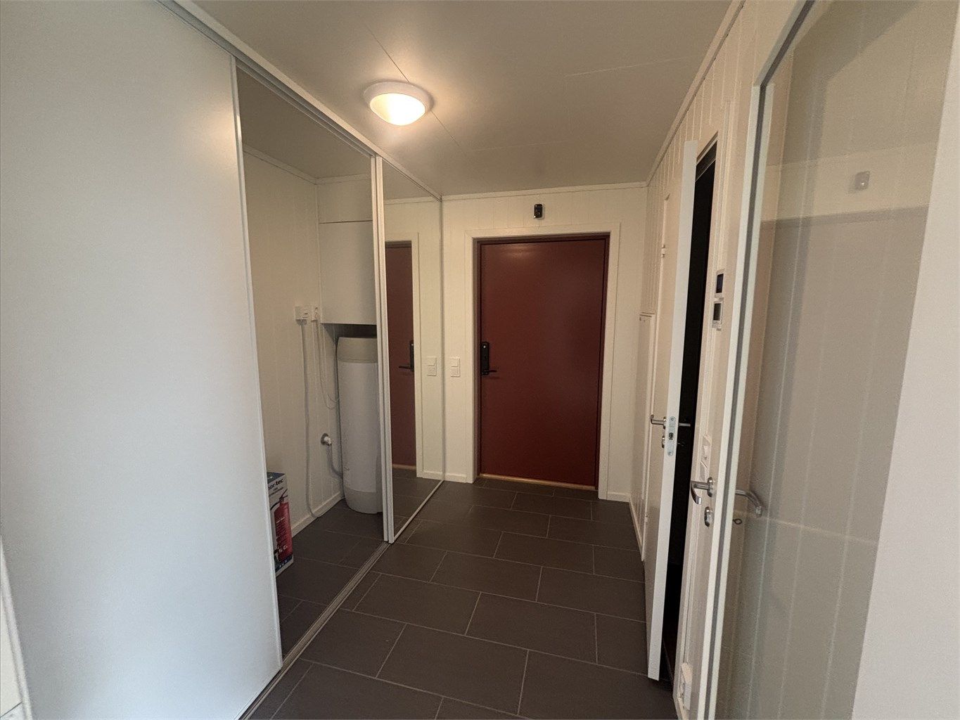 Innbydende gang med en skyvedørsgarderobe med lagringsmuligheter. 