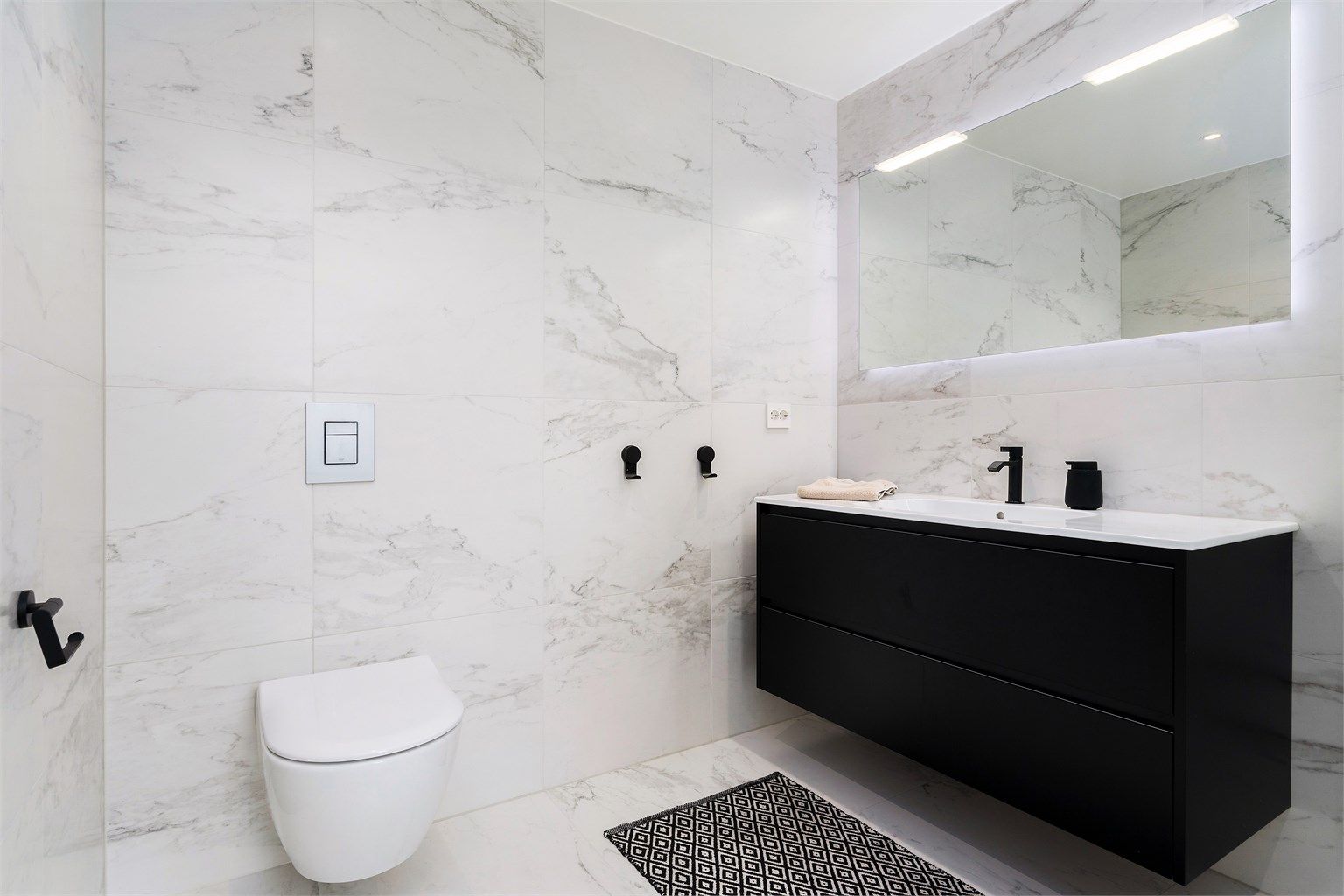 God baderomsinnredning som komplementeres med vegghengt speil og integrert belysning. Toalettet er fra Villeroy & Boch i tillegg har badet Devismart termostatstyring med mulighet for appstyring
