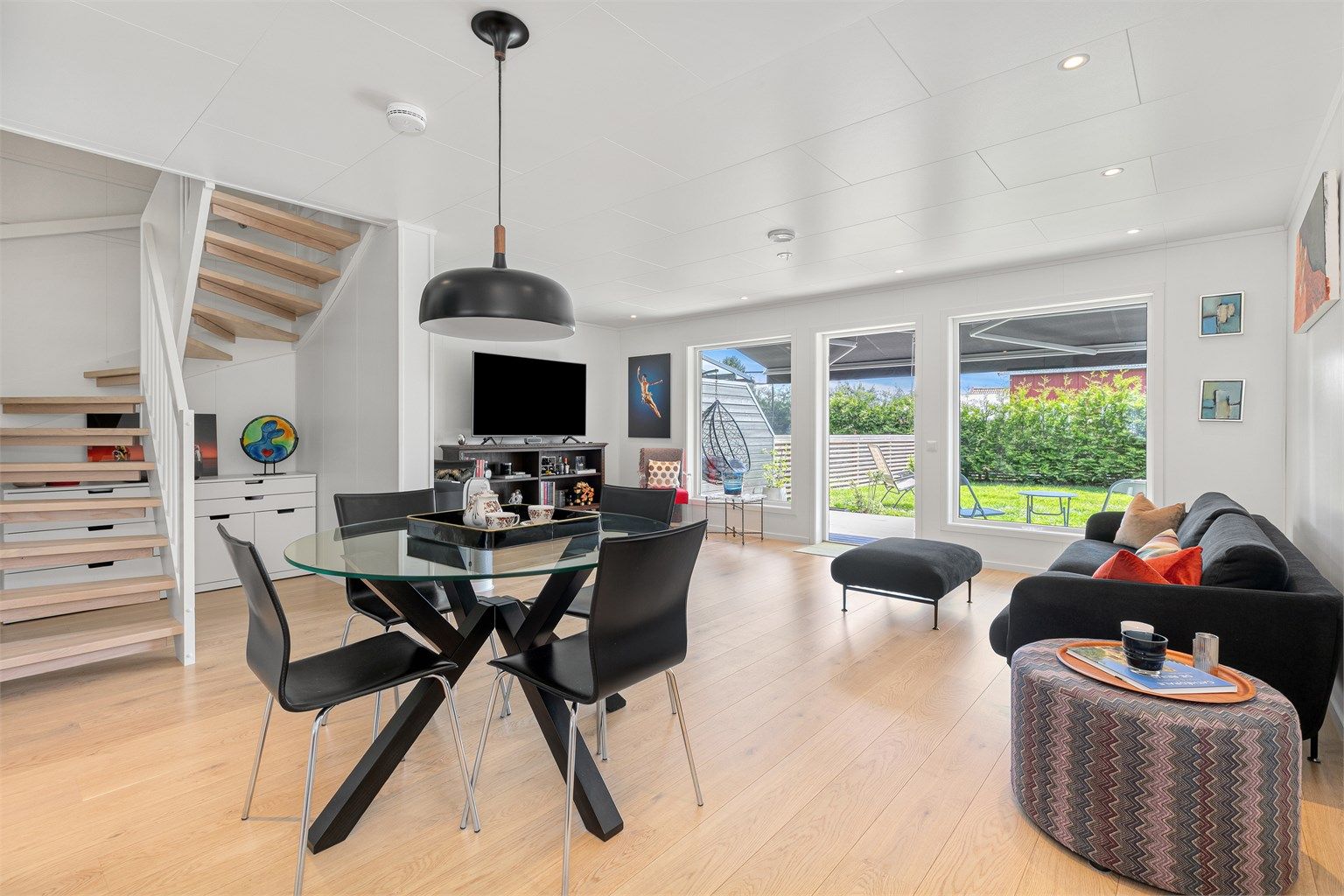 Lys og innbydende stue med utgang til solrik terrasse og hage