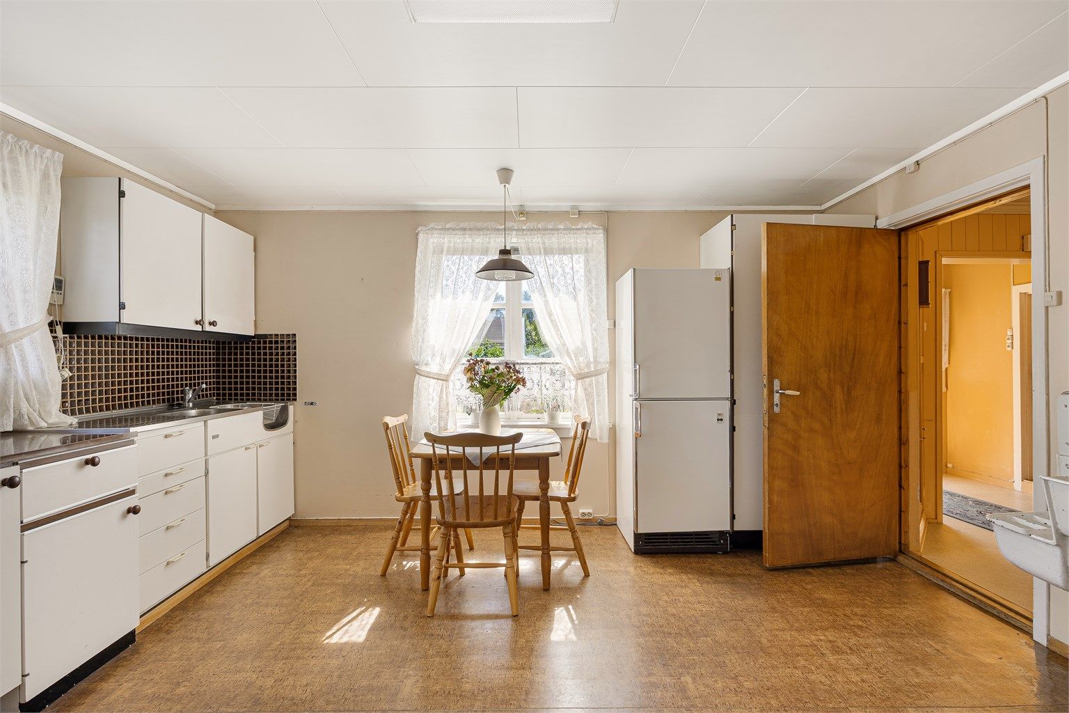 Kjøkkeninnredning med glatte fronter og laminert benkeplate.
