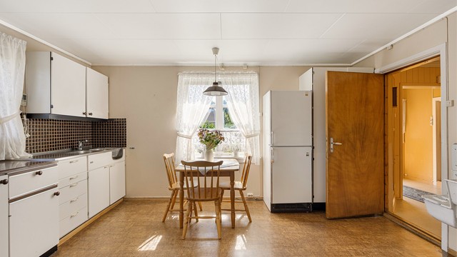 Kjøkkeninnredning med glatte fronter og laminert benkeplate.