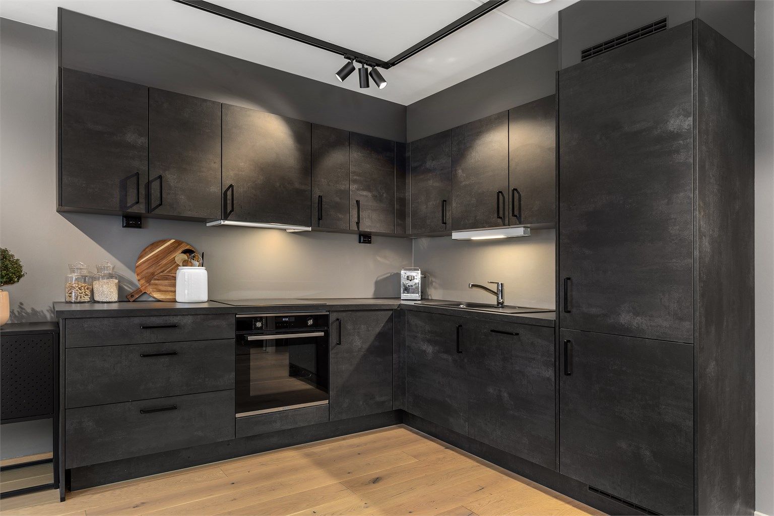 Delikat kjøkken i mørke slette fronter og med integrerte hvitevarer