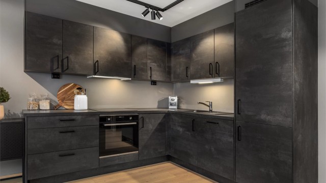 Delikat kjøkken i mørke slette fronter og med integrerte hvitevarer