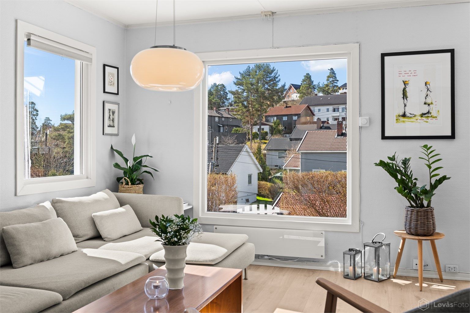 Vinduene i stuen rammer inn utsikten over det etablerte nabolaget.