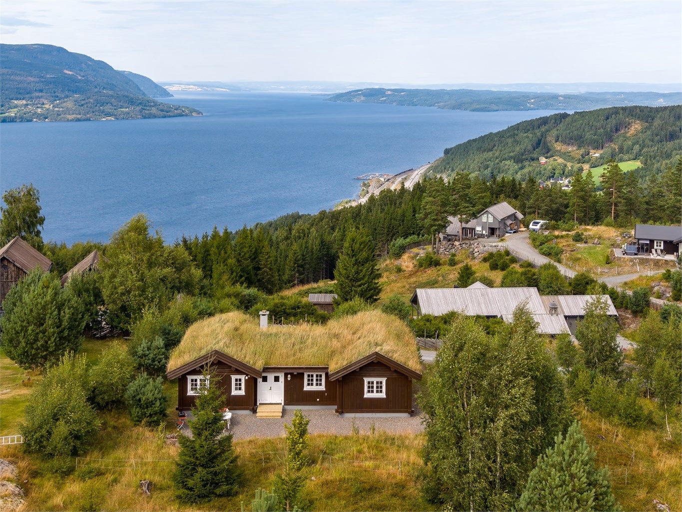 Velkommen til Lushattvegen 6! Flott og velholdt fritidsbolig på Mjøsli, med skjermet beliggenhet på en liten høyde og fin utsikt over Mjøsa. (Foto: Skildre v/Bjørnar Fjeldberg)
