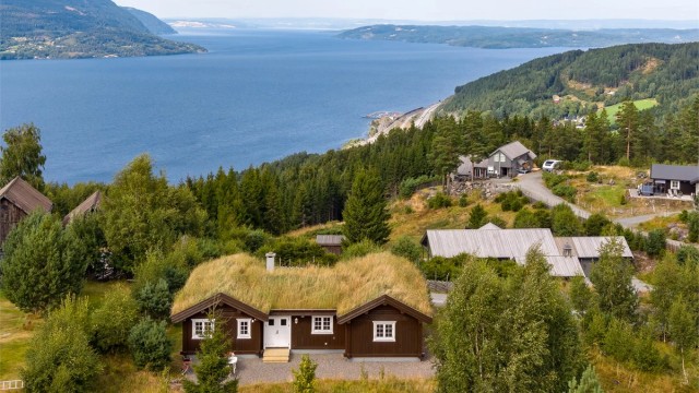 Velkommen til Lushattvegen 6! Flott og velholdt fritidsbolig på Mjøsli, med skjermet beliggenhet på en liten høyde og fin utsikt over Mjøsa. (Foto: Skildre v/Bjørnar Fjeldberg)