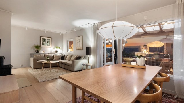 I stuen er det god plass til flere sosiale soner, både sofagruppe og spisestue. Det er en peis midt i rommet som sprer godt med varme og skaper en god atmosfære. Foto: Trond Reder
