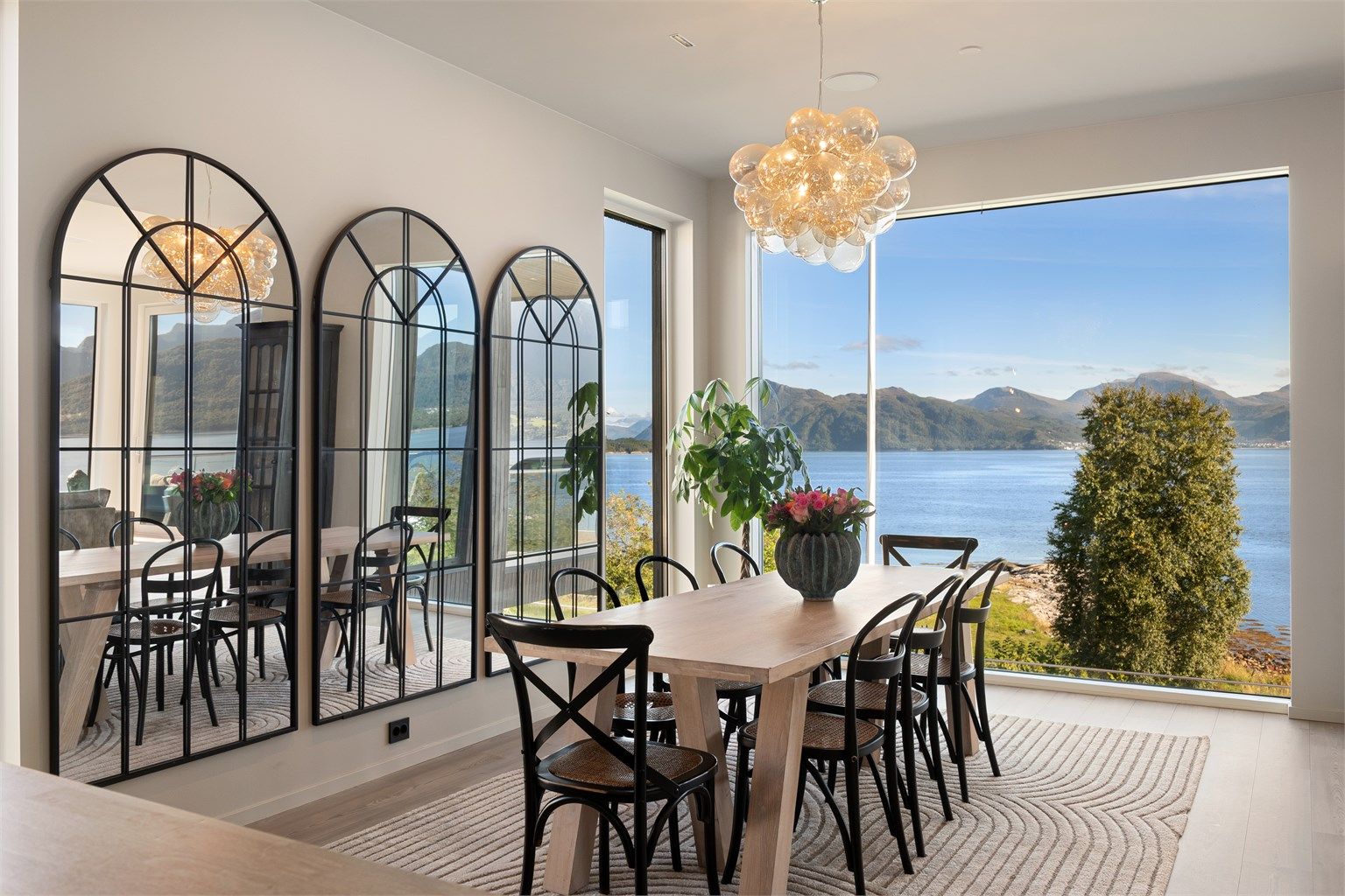 Store vindusflater slipper inn rikelig med dagslys og rammer inn fjordlandskapet.