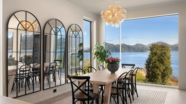 Store vindusflater slipper inn rikelig med dagslys og rammer inn fjordlandskapet.