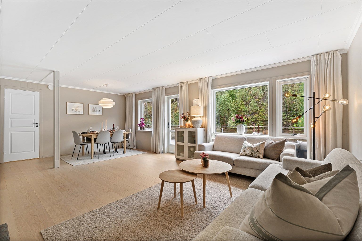 Stuen er lys og romslig, med store vindusflater og god plass til flere møbleringssoner.