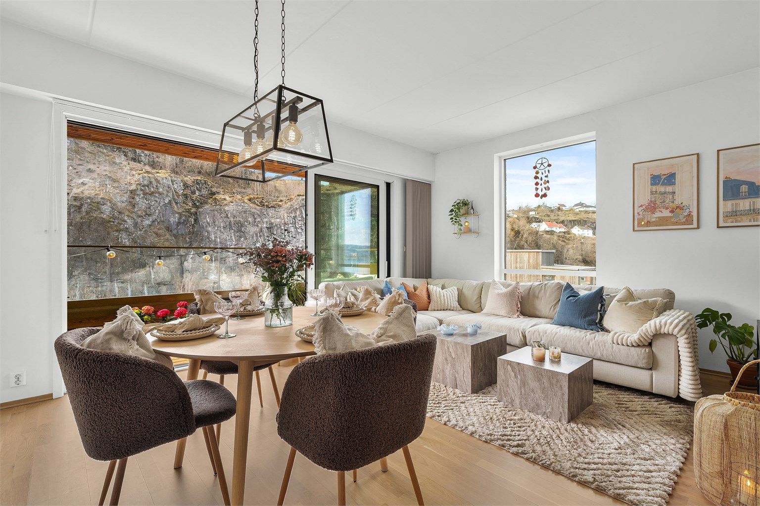 Store vindusflater og skyvedør mot terrassen gir en sømløs overgang mellom inne- og uterom.