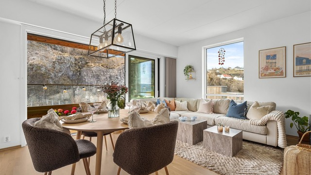 Store vindusflater og skyvedør mot terrassen gir en sømløs overgang mellom inne- og uterom.