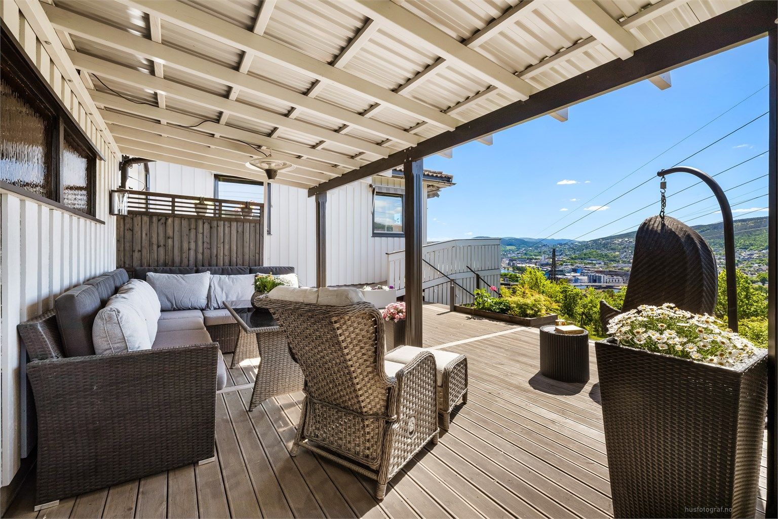 Stor, delvis overbygget terrasse på 47 m² med gulv av grålakkert Møre Royal terrassebord.
