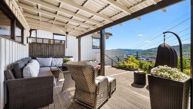 Stor, delvis overbygget terrasse på 47 m² med gulv av grålakkert Møre Royal terrassebord.