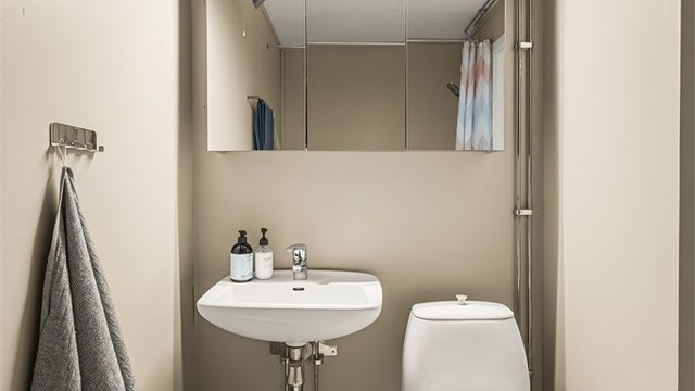 Badet er utstyrt med toalett, servant med speilskap og belysning.