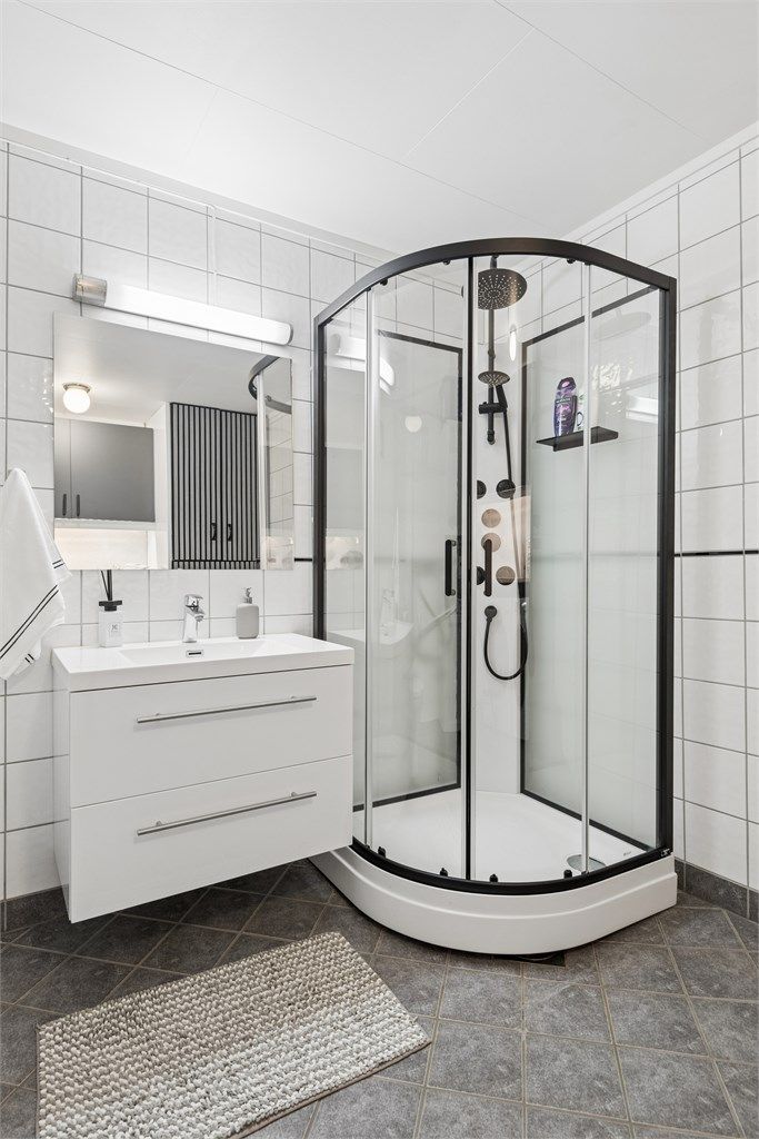 Videre er det dusjkabinett, gulvstående toalett og opplegg for vaskemaskin.