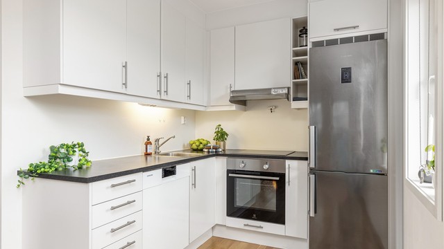 Laminert benkeplate med nedfelt vask, benkebelysning samt integrert stekeovn og platetopp.