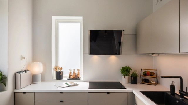 Pen kjøkkeninnredning med glatte fronter og benkeplater av laminat. Det er godt med skap- og benkeplass