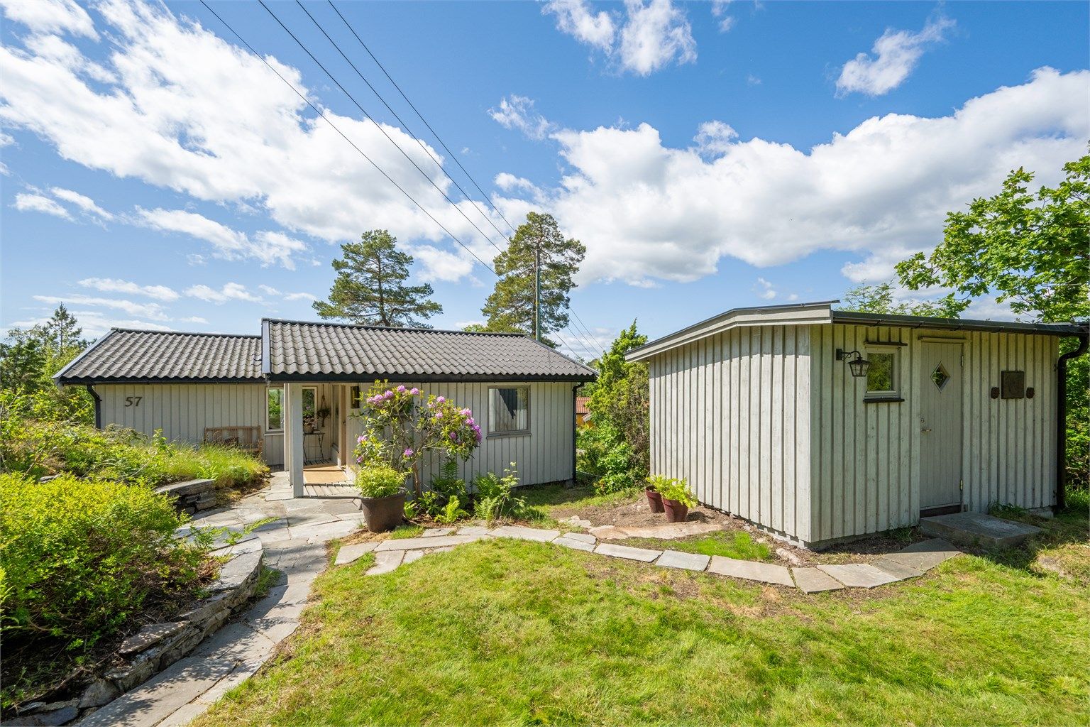 Her kan man flytte seg etter solen hele dagen på de hyggelige uteplassene. Eiendommen har naturlig uteareal med naturtomt, lyng, naturlig beplantning og trær