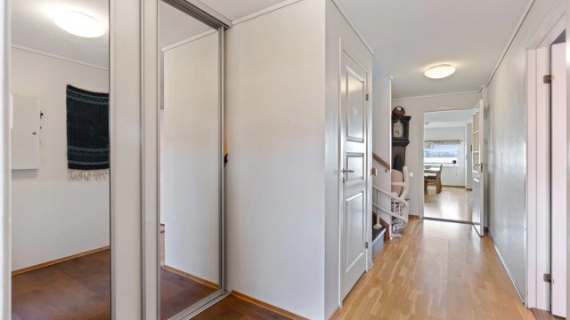 Entré med romslig skyvedørsgarderobe med speilfronter.