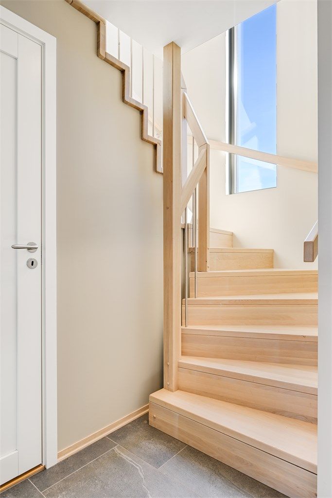 Trappen i heltre eik med stålspiler er et gjennomgående designelement som binder etasjene sammen.