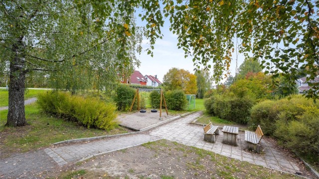 Fellesareal med lekeplass og sittebenker like ved boligen.