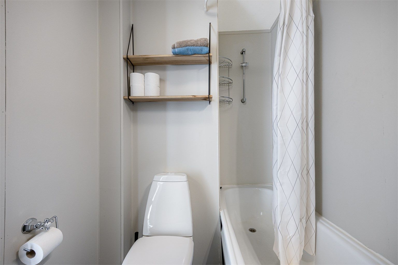 Vegger med våtromsplater og gulvbelegg. Rommet har naturlig avtrekk via ventil i himling.