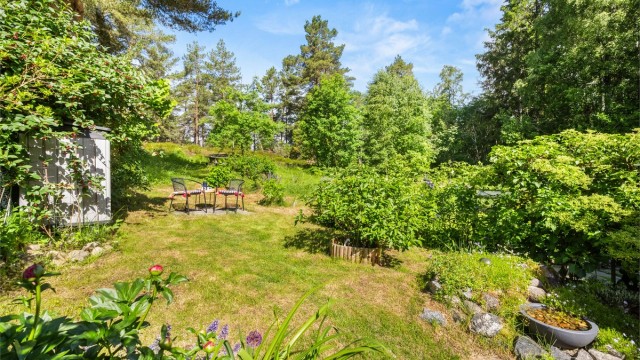 Eiertomten på 160 m² er opparbeidet med belegningsstein, terrasse på terreng, plenarealer og diverse beplantning.