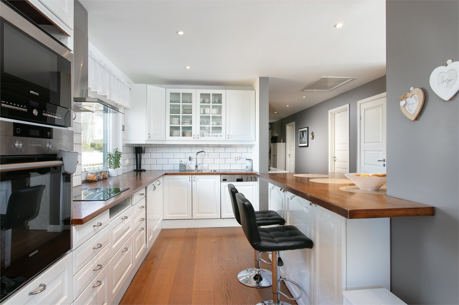 Kjøkkeninnredning med god skap og benkeplass. Utsikt mot nord mot bysentrum. Kjøkkenøy mot stuedel med sitteplasser