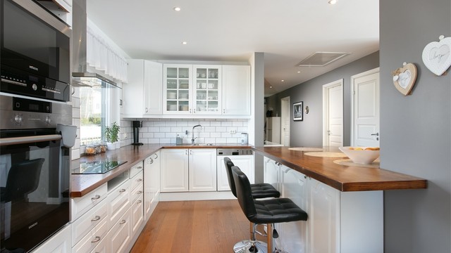 Kjøkkeninnredning med god skap og benkeplass. Utsikt mot nord mot bysentrum. Kjøkkenøy mot stuedel med sitteplasser