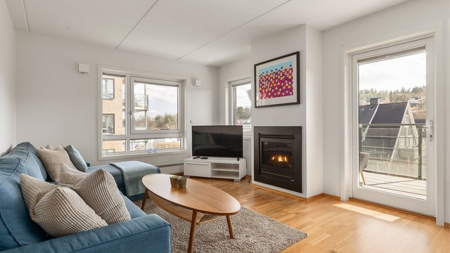 Store vindusflater som slipper inn mye naturlig lys. Mellom stue og spisestue er det utgang til en balkong på 17 kvm