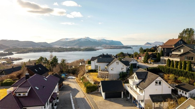 Dronebilde av eiendommen og nærområdet. Bildet er tatt fra øst mot vest