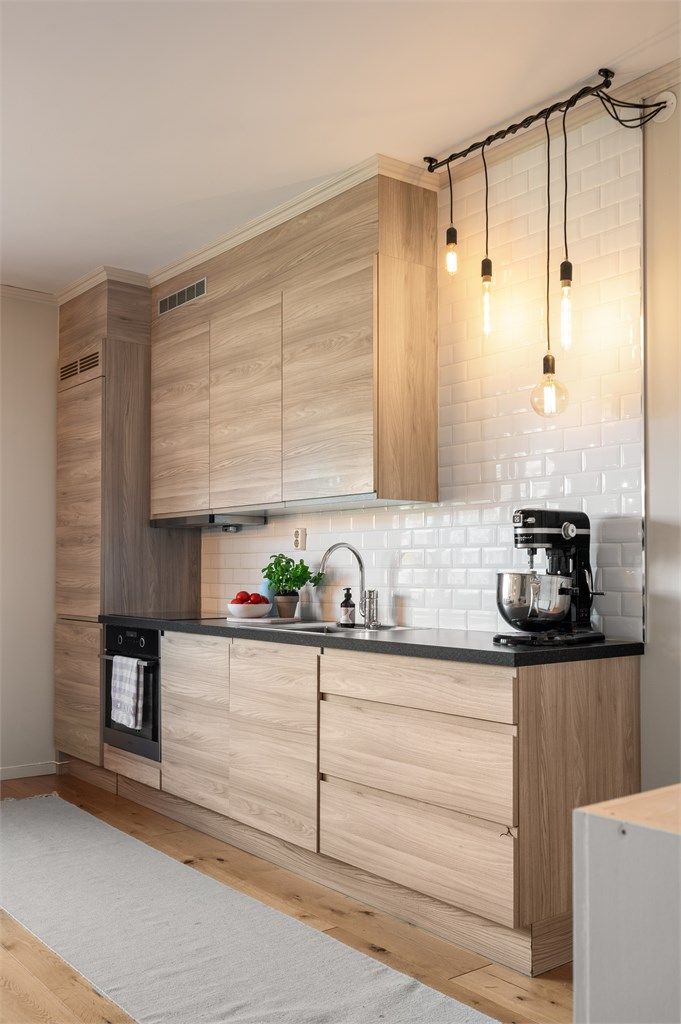 Fliser på veggen over benkeplaten beskytter og gir kjøkkenet et stilrent uttrykk.