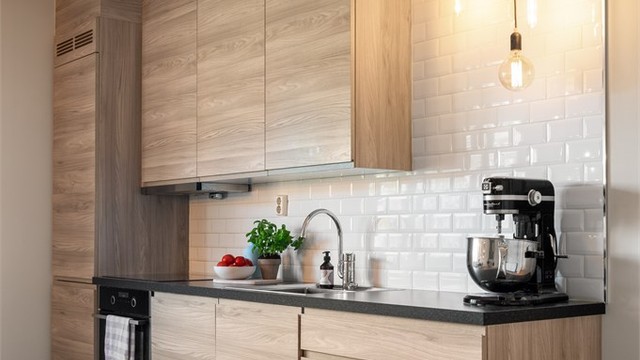 Fliser på veggen over benkeplaten beskytter og gir kjøkkenet et stilrent uttrykk.