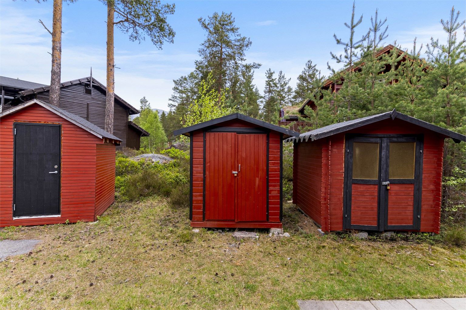 Det følger med en egen, frittstående bod for praktisk lagring av for eksempel ski- og turutstyr. Boden i midten av bildet følger leiligheten.