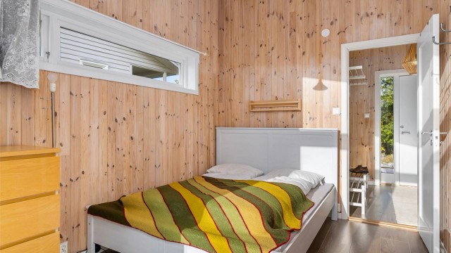 Rommet har en lys og luftig atmosfære med panel på veggene.