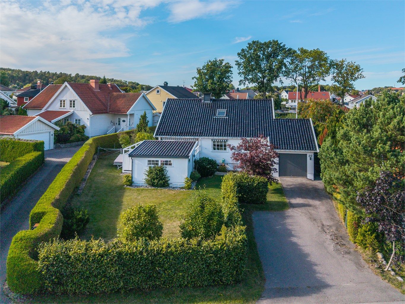 Asfaltert innkjørsel med integrert garasje og elbillader.