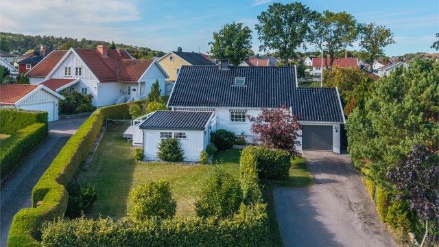 Asfaltert innkjørsel med integrert garasje og elbillader.