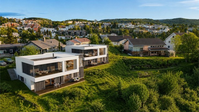 Begge boligene har fin beliggenhet i feltet med gode solforhold, og grenser til friareal. Det er gangavstand til butikk, flere skoler og barnehager, så her er alt tilrettelagt for en enkel hverdag. Bildet er AI-generert, avvik kan forekomme.