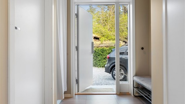 Entréen har store, lysegrå 60x60 cm fliser med varmekabler og innfelte downlights i taket.